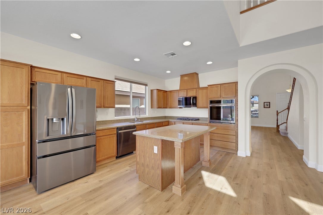 625 Bighorn Creek Street, Henderson, NV 89002 Warm wood cabinetry and a central island ground this open kitchen with hardwood flooring.