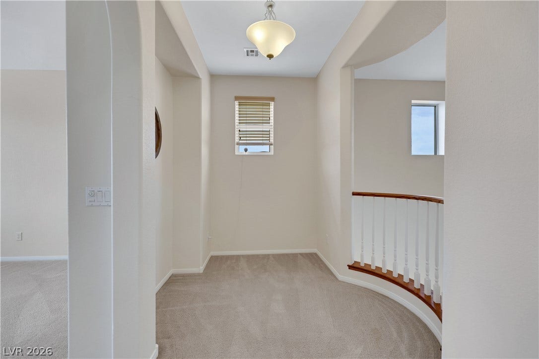 625 Bighorn Creek Street, Henderson, NV 89002 A well-lit landing area connects spaces with an elegant curved staircase and soft neutral carpeting.