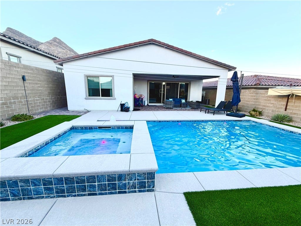11725 Hatchling Avenue, Las Vegas, NV 89138 An inviting backyard oasis features a clean-lined pool and raised spa set against mountain backdrops.