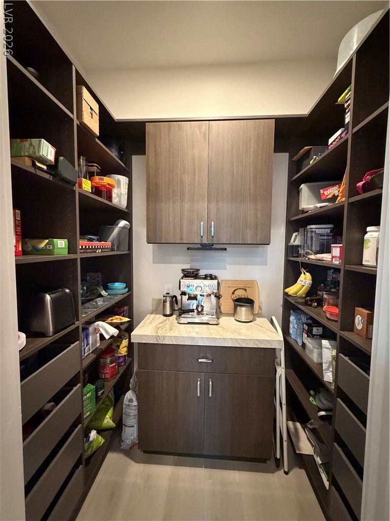 11725 Hatchling Avenue, Las Vegas, NV 89138 Floor-to-ceiling custom shelving and integrated stone-topped counters maximize storage space.