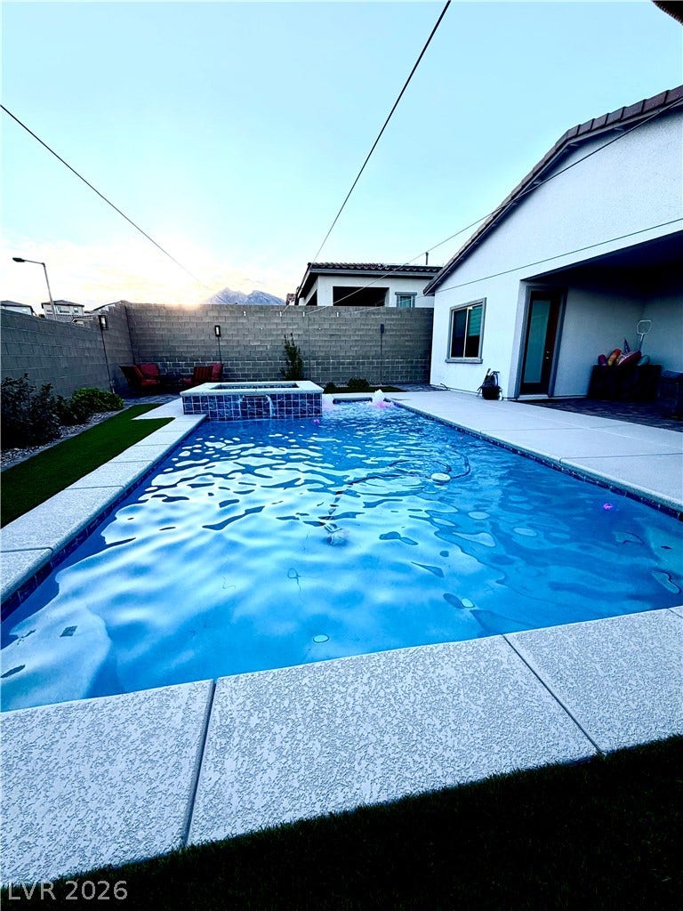 11725 Hatchling Avenue, Las Vegas, NV 89138 An inviting backyard oasis features a clean concrete patio surrounding a sparkling swimming pool.