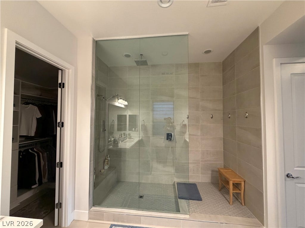 11725 Hatchling Avenue, Las Vegas, NV 89138 A spacious walk-in shower with modern floor-to-ceiling tiling and seamless glass doors.