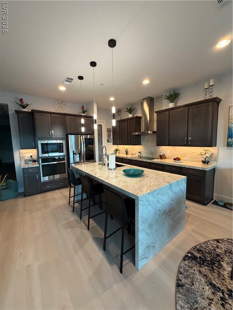 11725 Hatchling Avenue, Las Vegas, NV 89138 Rich wood cabinetry and spacious Quartzsite waterfall island define this contemporary culinary space.