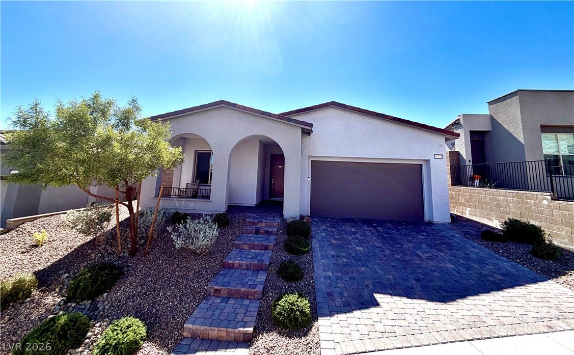 11725 Hatchling Avenue, Las Vegas, NV 89138 A stylish paver driveway and matching steps lead to this modern stucco home.