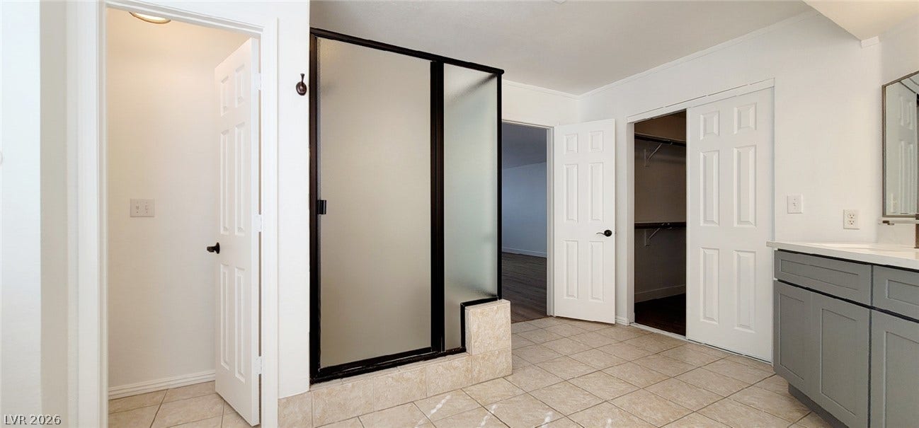 2001 Silverton Drive, Henderson, NV 89074 Tiled flooring and a frosted glass walk-in shower define this functional master bathroom layout.