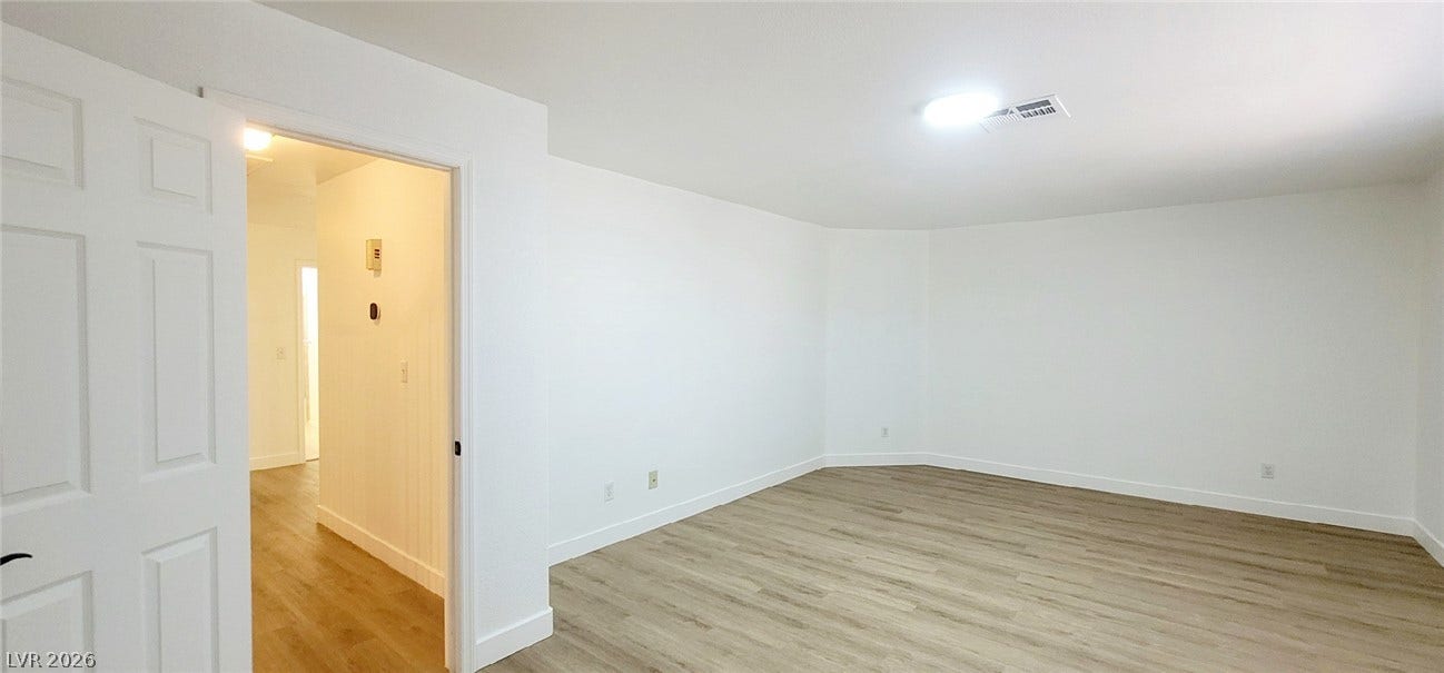 2001 Silverton Drive, Henderson, NV 89074 Smooth wood-style flooring anchors this versatile space featuring clean white walls and recessed lighting.