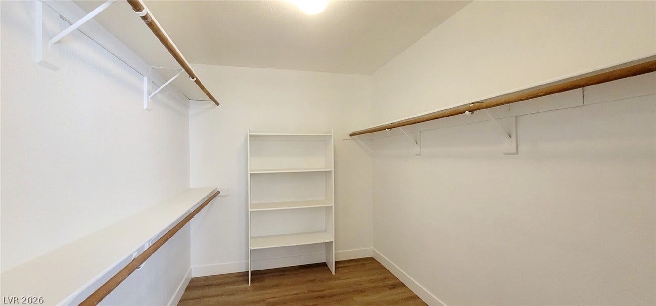 2001 Silverton Drive, Henderson, NV 89074 A spacious walk-in closet boasts generous built-in shelving, hanging rods, and wood flooring.