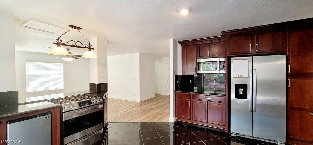 2001 Silverton Drive, Henderson, NV 89074 Gleaming stone counters and rich wood cabinetry define this modern open kitchen layout.