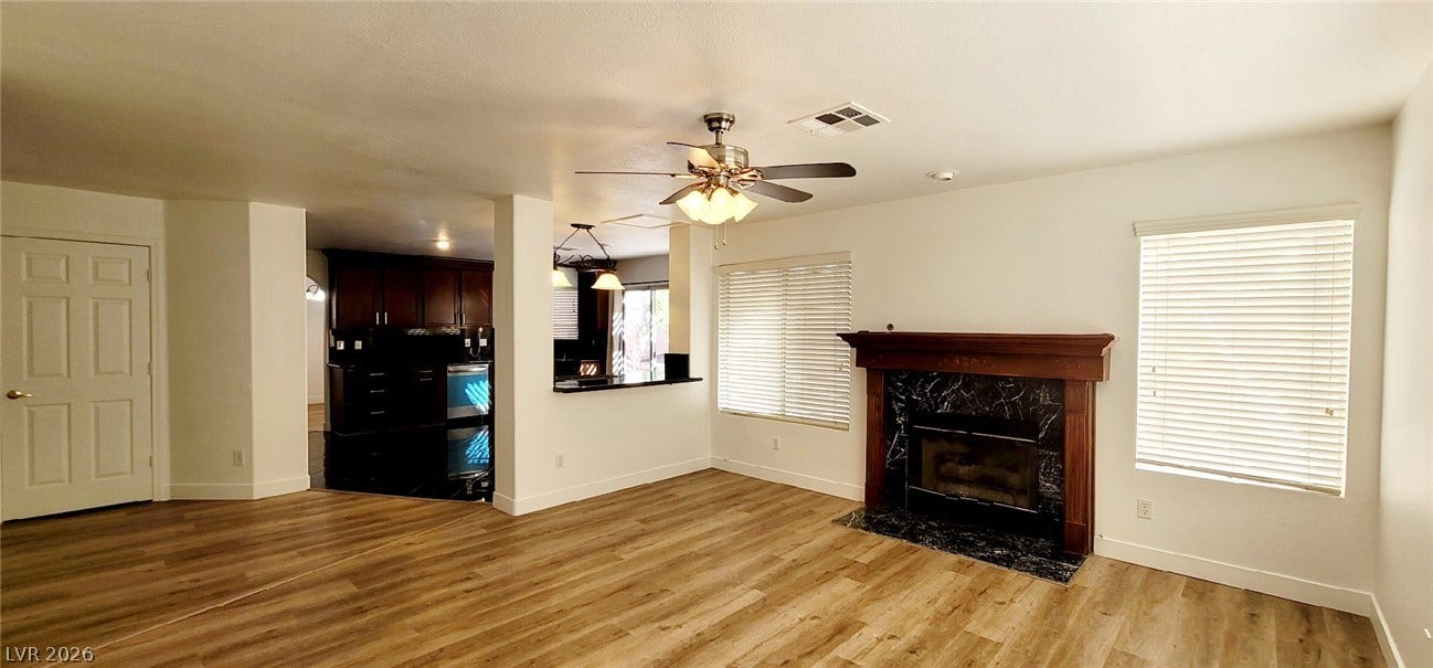 2001 Silverton Drive, Henderson, NV 89074 An inviting fireplace anchor this open living area with rich wood-look flooring.