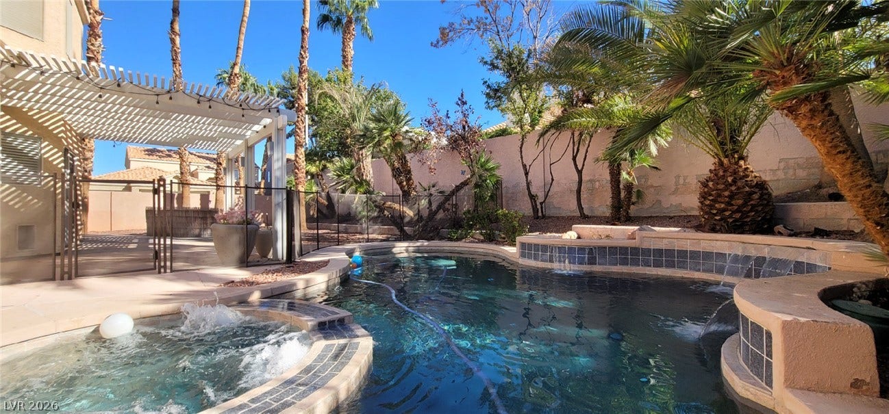 2001 Silverton Drive, Henderson, NV 89074 Mature palms frame a shimmering backyard pool and integrated spa under clear desert skies.