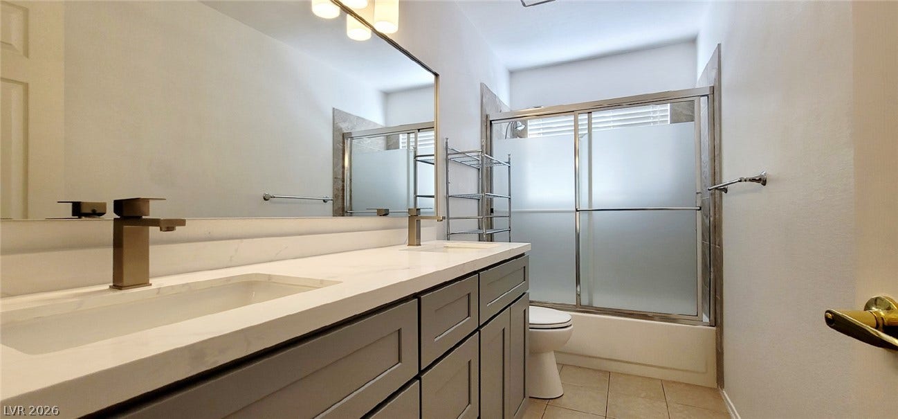 2001 Silverton Drive, Henderson, NV 89074 A modern double vanity updates this well-appointed bathroom complete with a glass-enclosed shower.