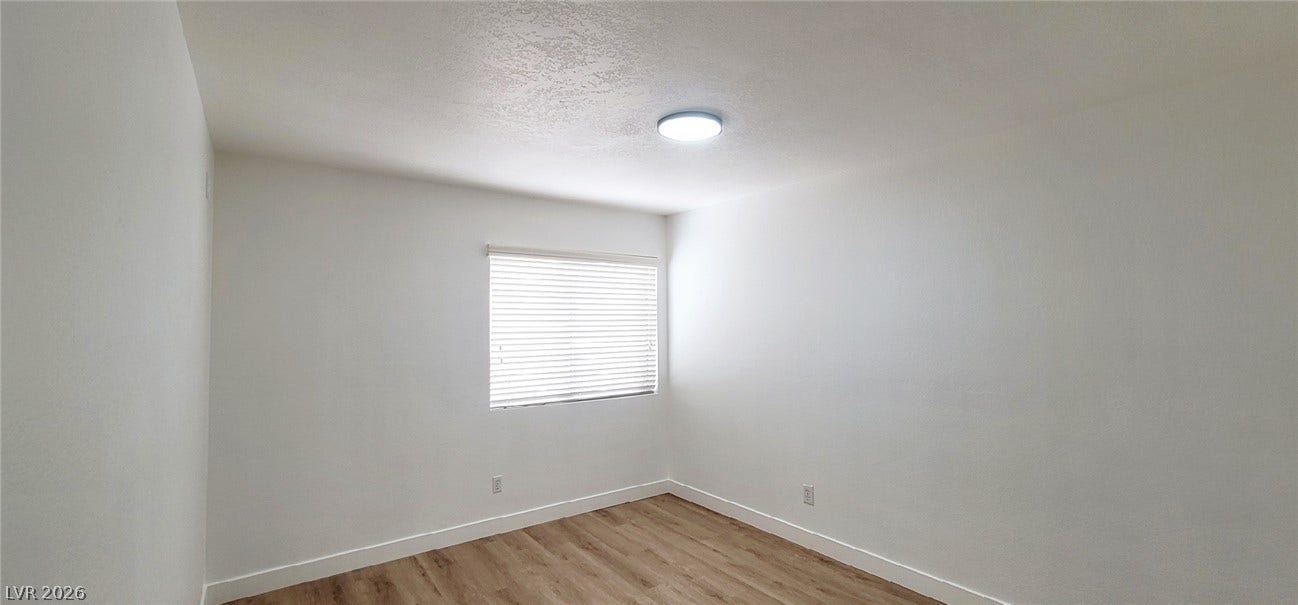 2001 Silverton Drive, Henderson, NV 89074 Clean lines and warm wood-style flooring define this versatile, minimalist room.