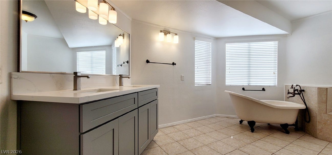 2001 Silverton Drive, Henderson, NV 89074 A spacious layout showcases a double vanity alongside a classic clawfoot tub and tiled flooring.