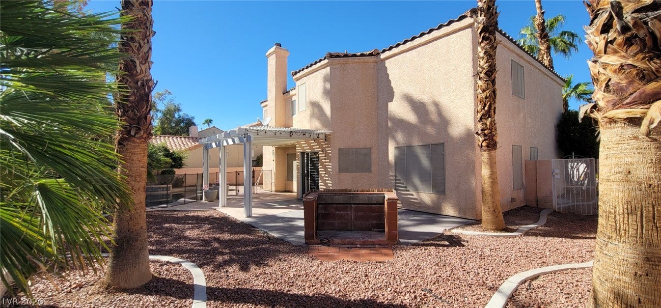 2001 Silverton Drive, Henderson, NV 89074 A spacious backyard patio area is framed by towering palm trees under clear blue skies.