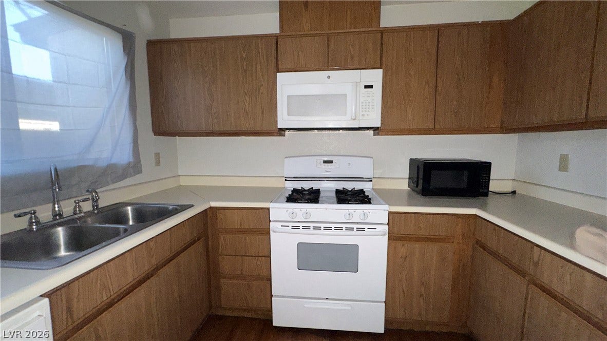 543 KRISTIN Lane, Henderson, NV 89011 Ample wooden cabinetry and durable laminate countertops wrap around this functional kitchen workspace.