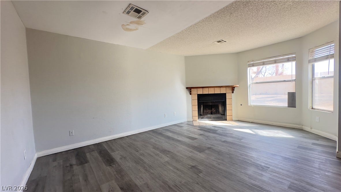 543 KRISTIN Lane, Henderson, NV 89011 An inviting corner fireplace and durable wood-look flooring ground this spacious living area.