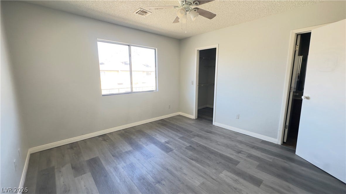 543 KRISTIN Lane, Henderson, NV 89011 Smooth wood-look flooring and a walk-in closet highlight this bedroom space.