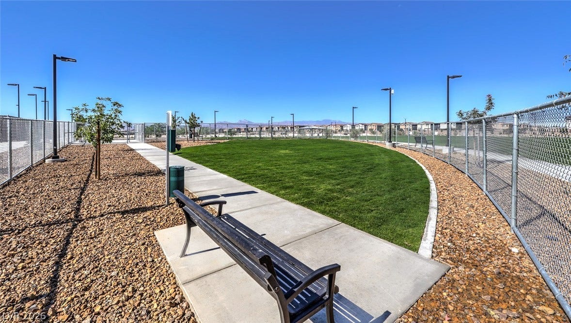 A community park with a lush green lawn and walking paths offers an inviting outdoor retreat.