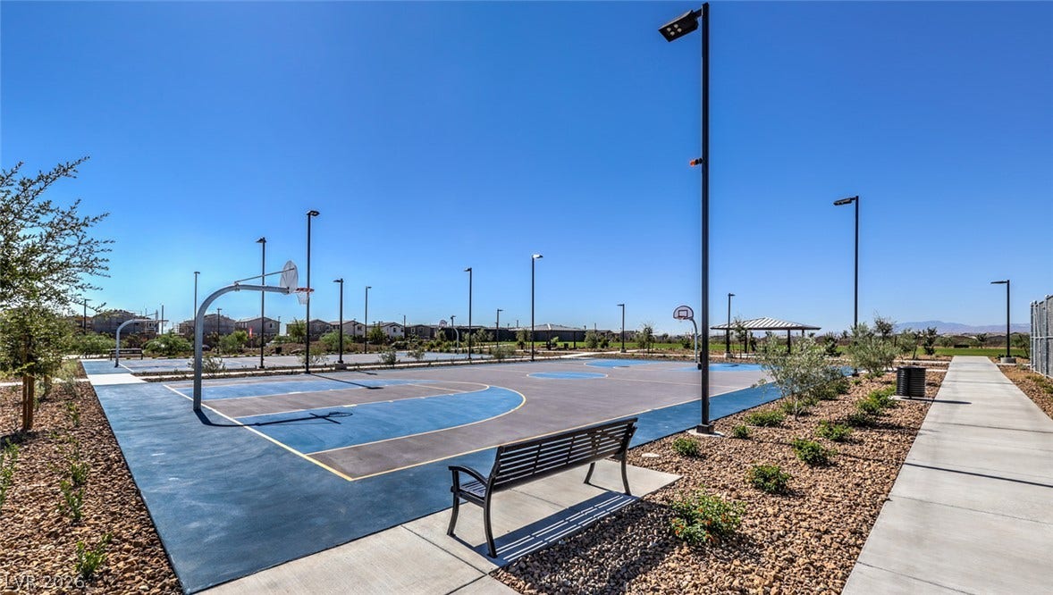An inviting outdoor basketball court awaits, complete with multiple hoops and ample lighting for evening play.