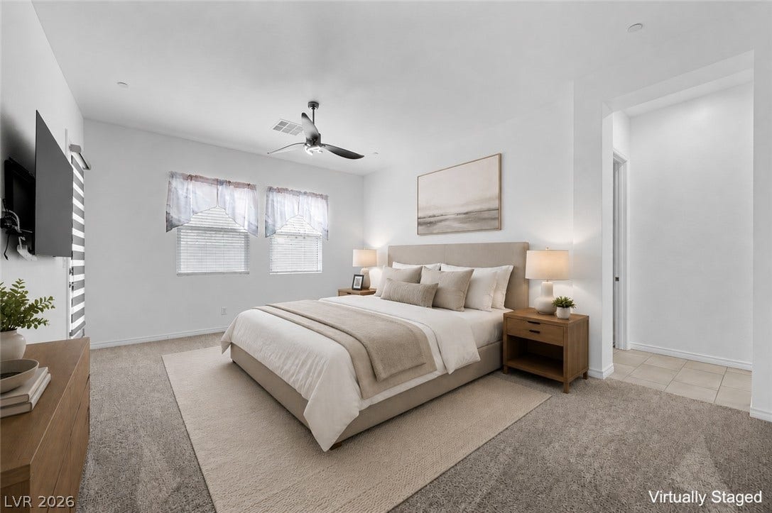 An inviting Primary bedroom features plush carpeting, access to patio, recessed lighting, and large windows that fill the space with light.