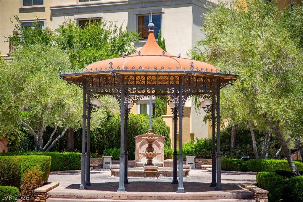 A charming wrought iron gazebo stands centered within beautifully manicured courtyard gardens of the Lake Las Vegas Village.