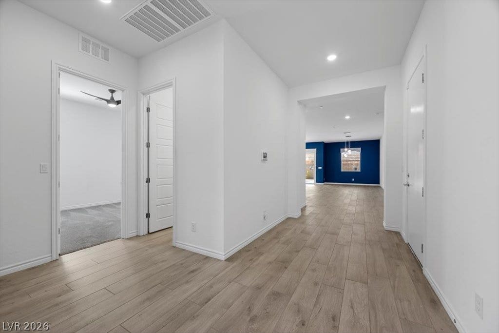 An inviting hallway featuring wood-look flooring connects seamlessly to an open-concept living space.