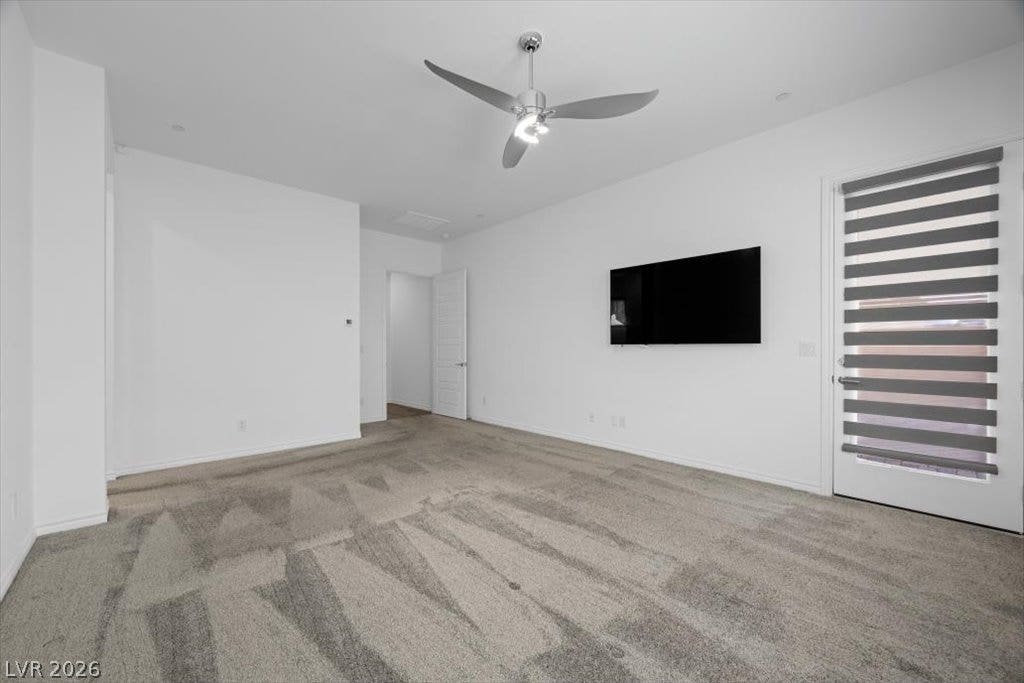 Plush carpeting and crisp walls and door leading to patio set this primary bedroom off.