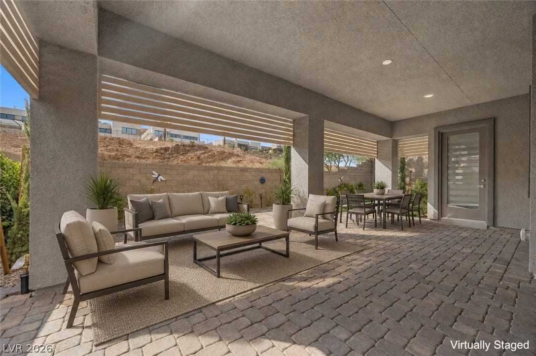 An inviting covered patio features extensive use of pavers and recessed lighting.
