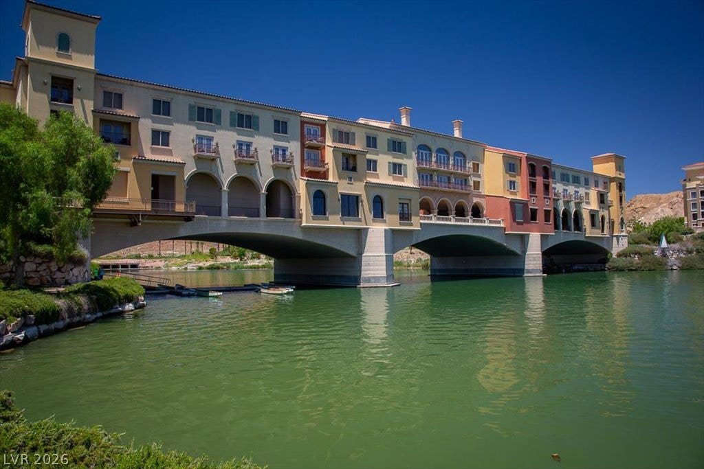 Mediterranean-inspired architecture arches over peaceful  Lake Las Vegas under a clear blue sky.