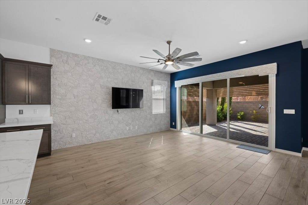 Sliding glass doors connect the spacious main living area to a covered back patio.