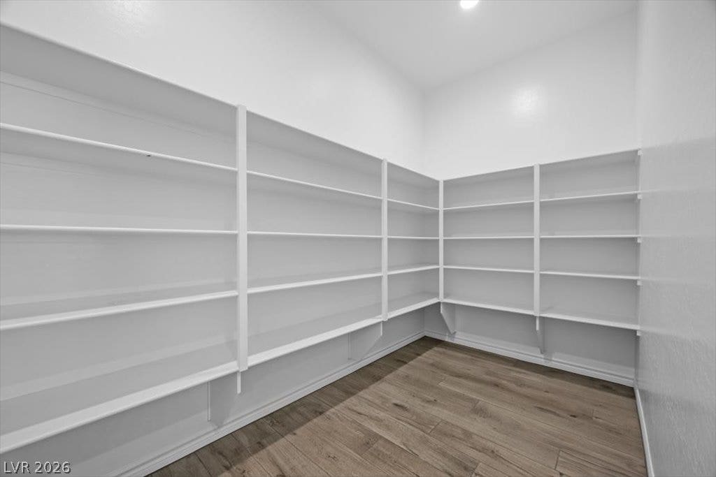 Generous built-in shelving wraps around this storage space finished with durable wood-look flooring.