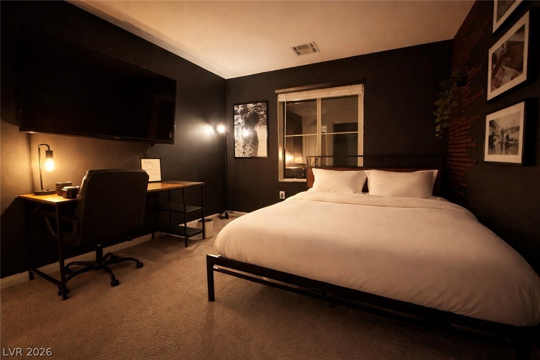 6483 Perch Coo Avenue, Las Vegas, NV 89130 Plush carpeting anchors this contemporary bedroom containing dark finished walls and a built-in window.