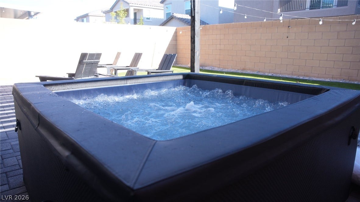 6483 Perch Coo Avenue, Las Vegas, NV 89130 A private hot tub anchors this paved patio area set within a walled backyard.