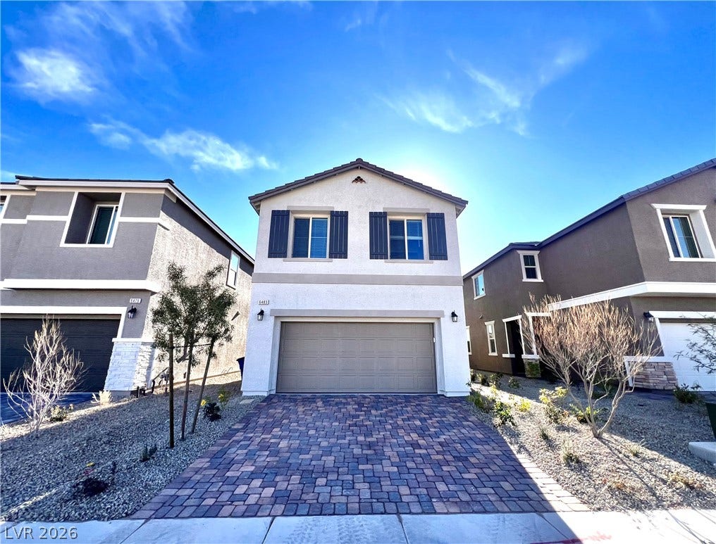 6483 Perch Coo Avenue, Las Vegas, NV 89130 An inviting two-story exterior showcases a handsome paver driveway and clean stucco finishes.