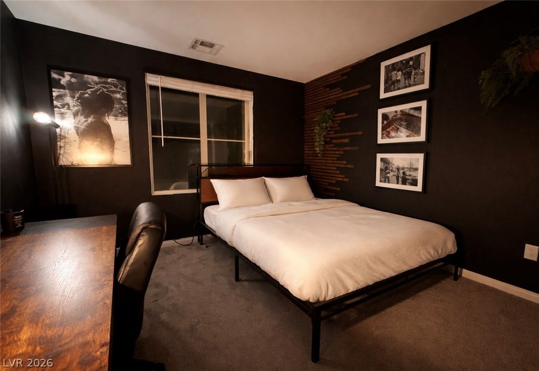 6483 Perch Coo Avenue, Las Vegas, NV 89130 Dark, moody walls contrast with soft carpeting in this cozy bedroom retreat.