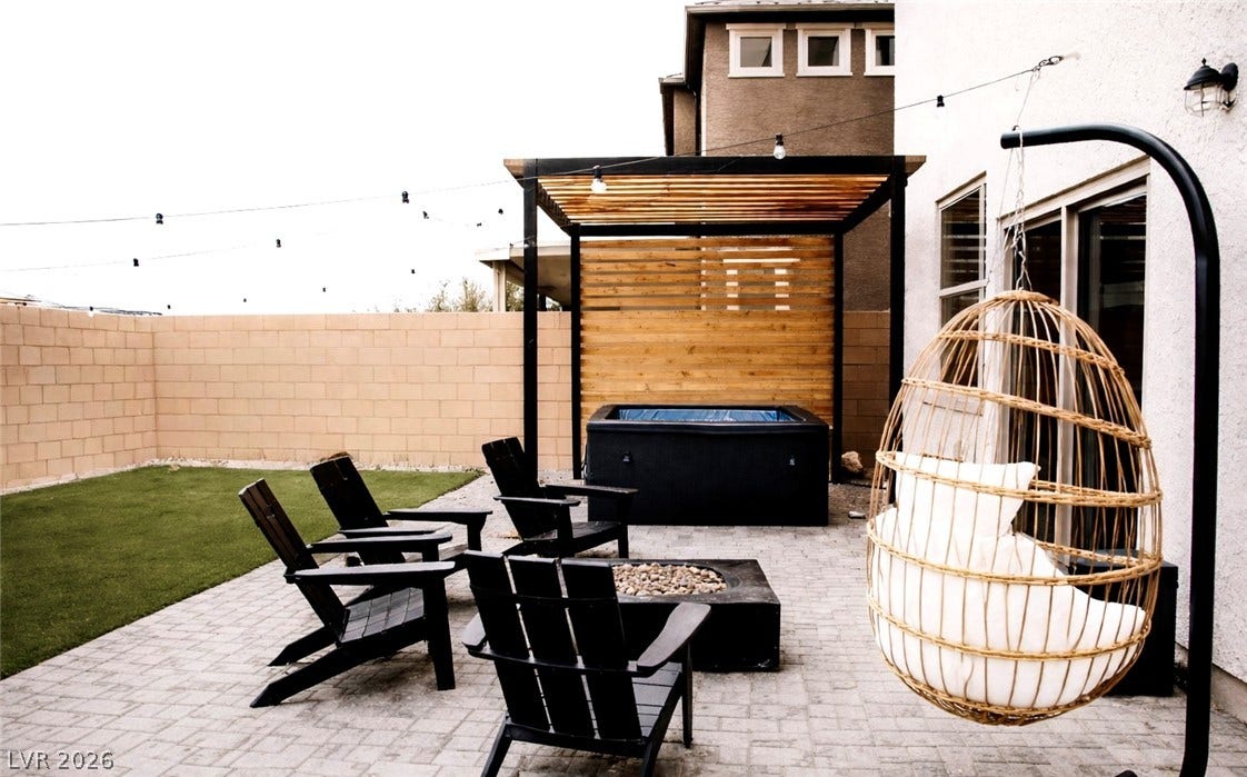 6483 Perch Coo Avenue, Las Vegas, NV 89130 An inviting stone paver patio features a fire pit and a sheltered hot tub.