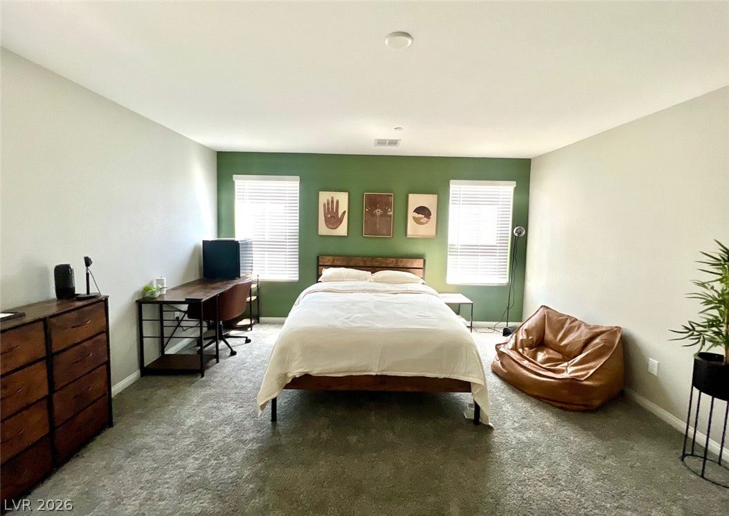 6483 Perch Coo Avenue, Las Vegas, NV 89130 Natural light streams through dual windows highlights the plush carpeting in this bedroom.