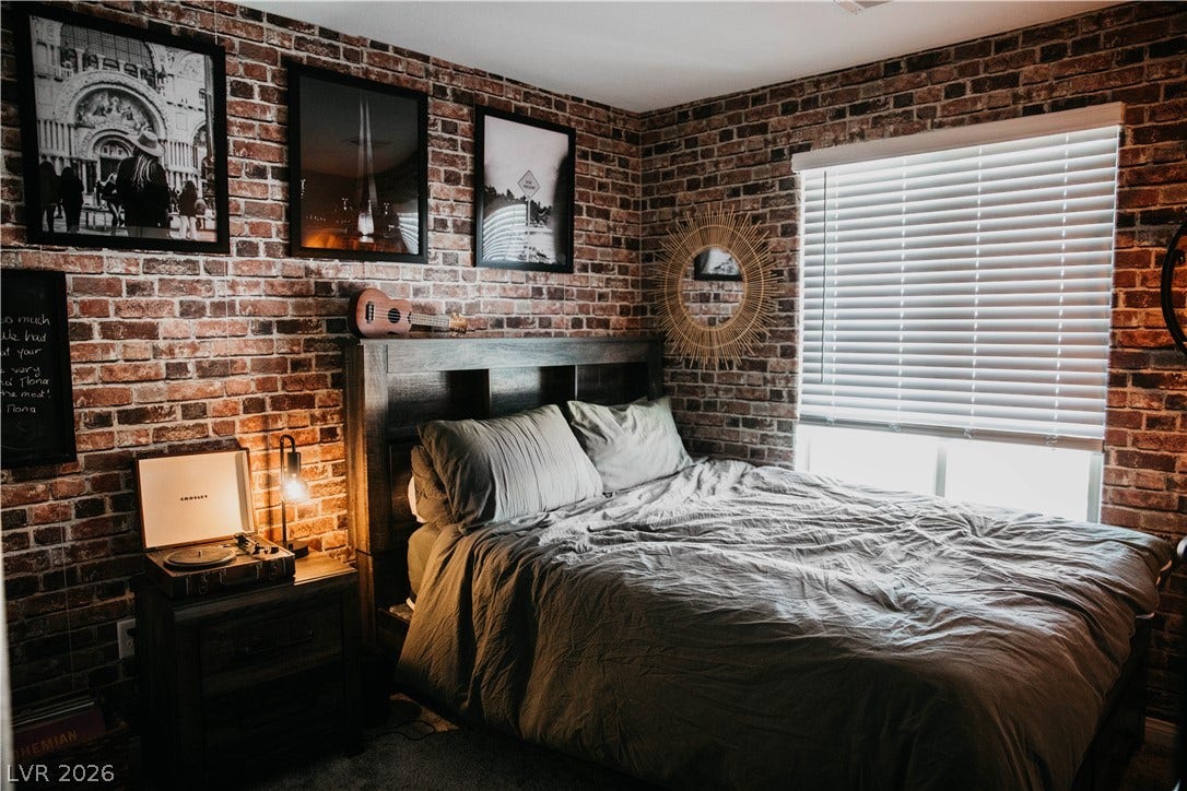 6483 Perch Coo Avenue, Las Vegas, NV 89130 Industrial style defines this cozy retreat featuring classic brick walls and large windows.