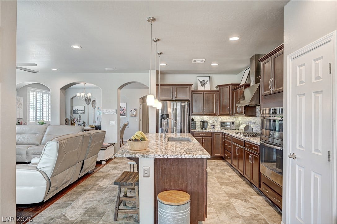 3605 Greenbriar Bluff Avenue, North Las Vegas, NV 89081 Rich wood cabinetry and expansive granite countertops define this modern, open-concept kitchen.