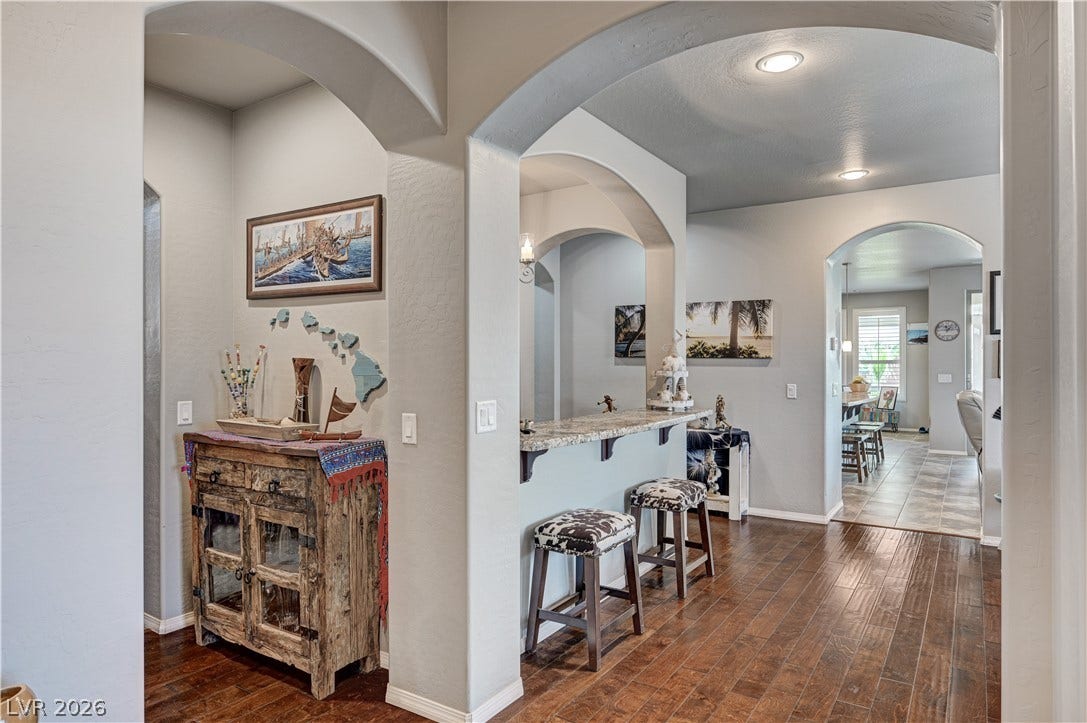 3605 Greenbriar Bluff Avenue, North Las Vegas, NV 89081 Classic arched openings frame views across polished hardwood floors into light-filled living spaces.