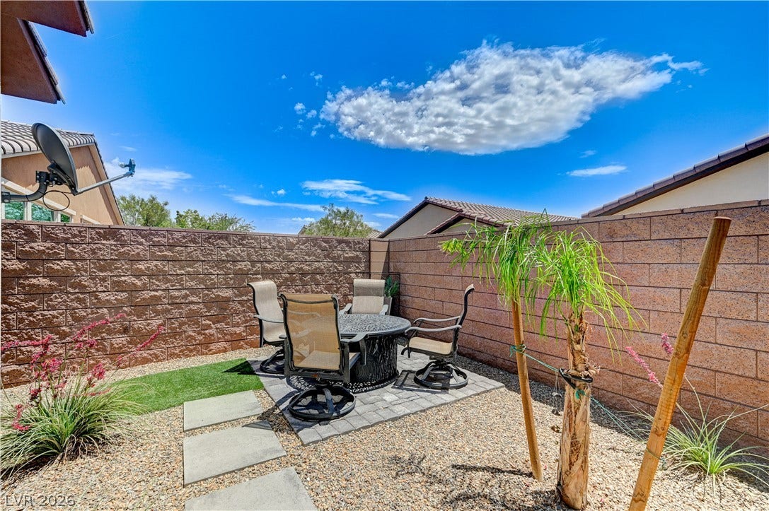 3605 Greenbriar Bluff Avenue, North Las Vegas, NV 89081 An enclosed backyard patio framed by solid masonry block walls under clear blue skies.