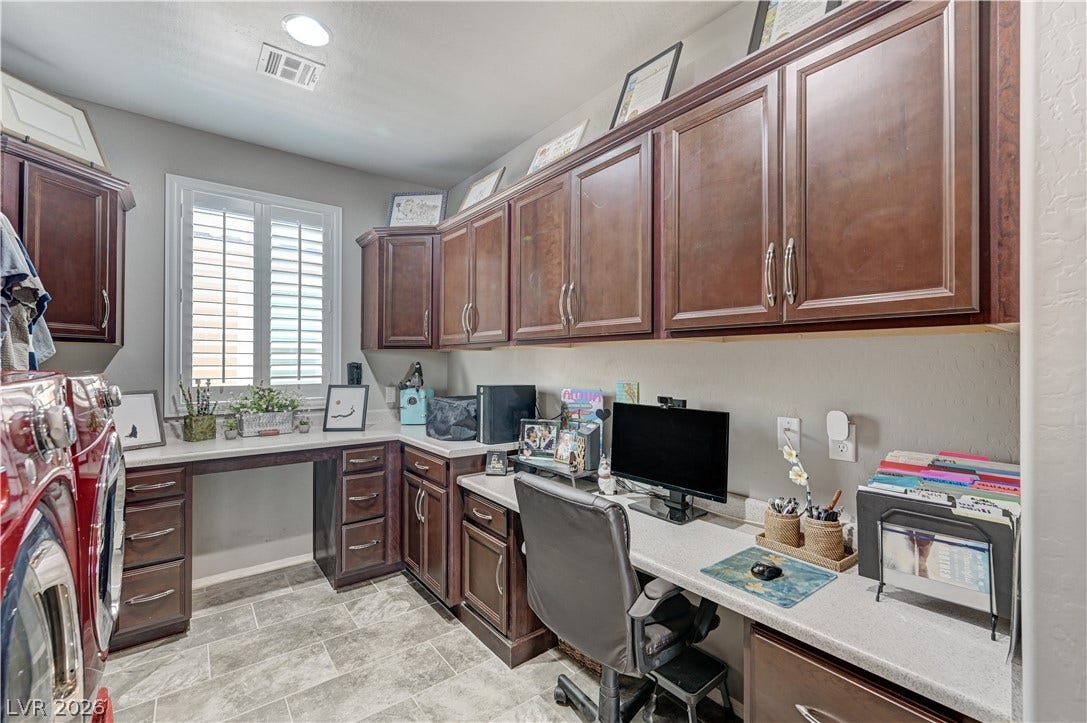 3605 Greenbriar Bluff Avenue, North Las Vegas, NV 89081 A spacious utility room features extensive wood cabinetry and integrated desk space over tile flooring.