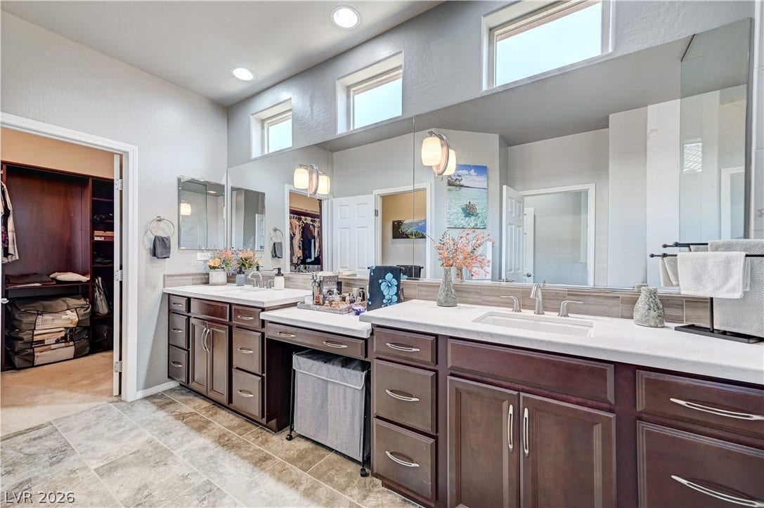 3605 Greenbriar Bluff Avenue, North Las Vegas, NV 89081 A spacious double vanity matches the tiled flooring under high clerestory windows.