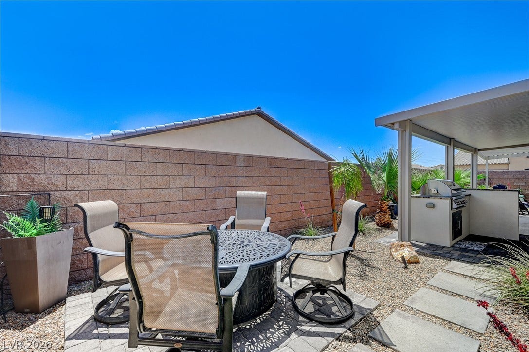 3605 Greenbriar Bluff Avenue, North Las Vegas, NV 89081 An inviting outdoor kitchen area and stone patio space sit enclosed by a private block fence.