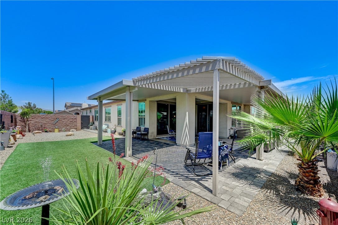 3605 Greenbriar Bluff Avenue, North Las Vegas, NV 89081 An inviting paved patio sits beneath a spacious pergola looking out over the manicured yard.