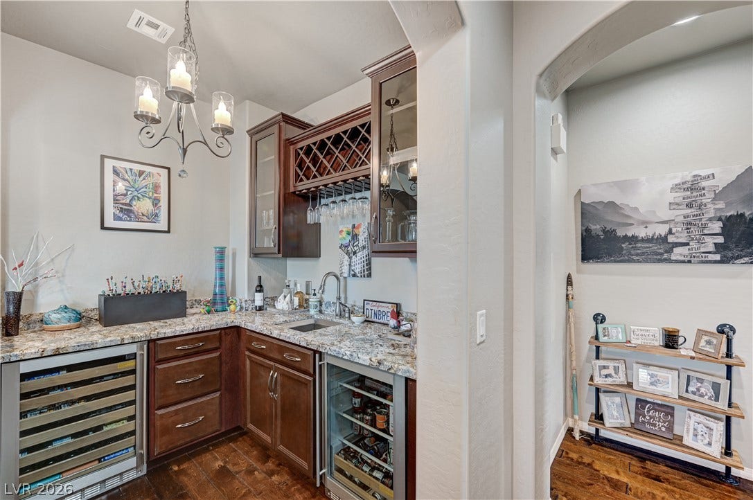 3605 Greenbriar Bluff Avenue, North Las Vegas, NV 89081 Rich hardwood flooring complements custom cabinetry and stone countertops in this elegant home bar.
