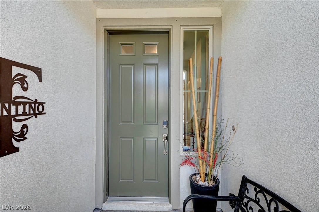 3605 Greenbriar Bluff Avenue, North Las Vegas, NV 89081 A classic front entrance framed by clean stucco walls and a tall sidelight window.