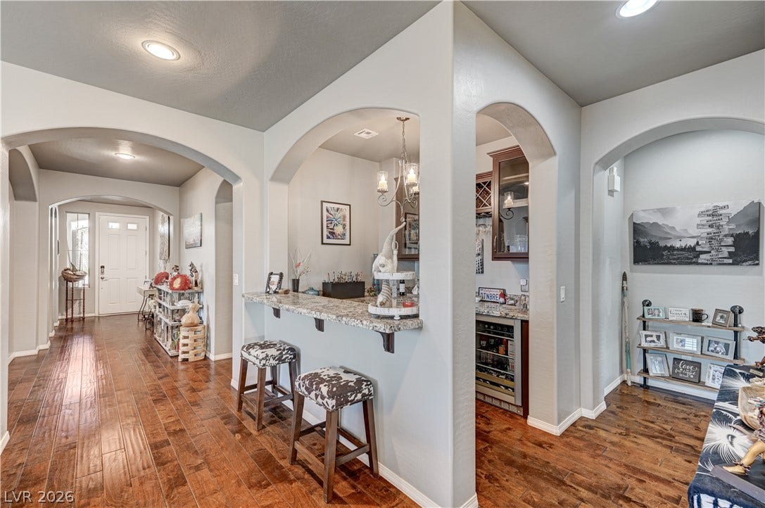 3605 Greenbriar Bluff Avenue, North Las Vegas, NV 89081 Gleaming hardwood floors and graceful arched openings connect the inviting hallway to a built-in bar.