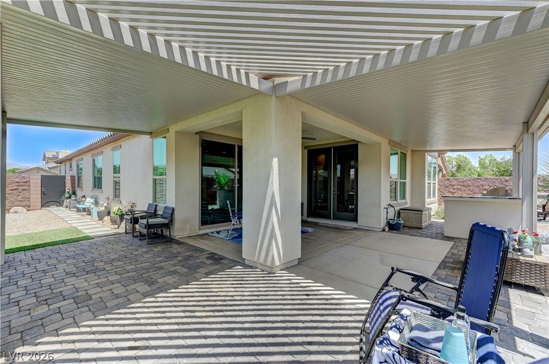 3605 Greenbriar Bluff Avenue, North Las Vegas, NV 89081 A spacious covered patio transitions seamlessly to paver decking alongside stucco exterior walls.