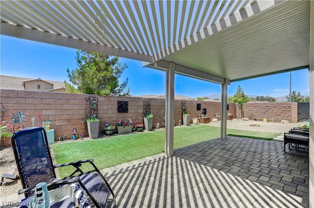 3605 Greenbriar Bluff Avenue, North Las Vegas, NV 89081 An inviting covered patio features elegant paver stone flooring looking out over the private yard.